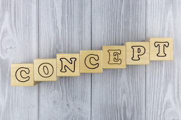 Fototapete - Wooden blocks with letters spelling the word - Concept - arranged diagonally on a grey wood background with copyspace. Flat lay, top view