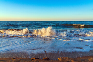 Wall Mural - Empty beach with yellow sand and blue waves, quarantine at the resort