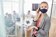 © Robert Kneschke - Business Frau mit Maske telefoniert mit Smartphone