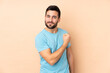 © luismolinero - Caucasian handsome man isolated on beige background proud and self-satisfied