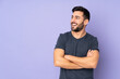 © luismolinero - Caucasian handsome man happy and smiling over isolated purple background