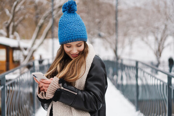 Beautiful happy young woman in winter jacket standing