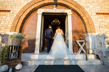 Bride and groom entering in a church in wedding dress
