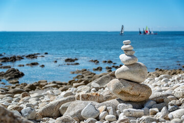 Wall Mural - Pile of stones on a beach, ocean background in Brittany, France