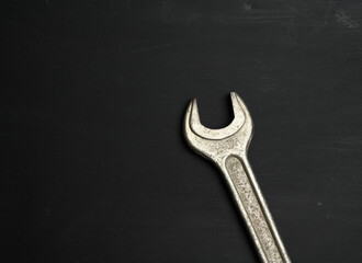 metal wrench for nuts on a black background, close up