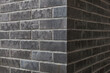 Old anthrazit brick wall. Wall texture. Brick wall corner. 
Alte dunkelgraue Backsteinmauer. Wandbeschaffenheit. 
Ziegelmauer Ecke.