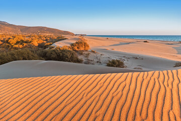 Wall Mural - Patara beach is a famous tourist landmark and natural destination in Turkey. Majestic view of orange sand dunes and hills glows in the rays of the warm sunset.