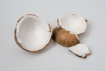 Canvas Print - Parts of fruits coconut on a light grey background,Cracked coconut