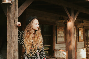 Wall Mural - The girl meets the morning near the western house, traveling alone. A woman in a village outside the city relaxes, laughs, rest in the forest. 