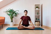 Man Meditating At Home, Sitting With Legs Crossed