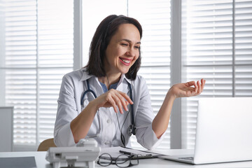 Poster - Doctor with headset and laptop consulting patient online in office. Hotline service