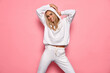 © kiuikson - Beautiful blonde woman wear of white set of track suit isolated on pastel background