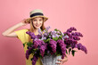 © zamuruev - Portrait of a happy beautiful young girl with basket full of lilac on pink background.