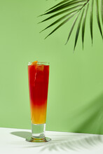 Strawberry And Peach Lemonade Drink Over Green Background. White Table With Sunshine And Palm Leaf Shadow Still Life. Summer, Fresh, Healthy And Tropic Concept