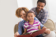 Parents With Daughter Reading Book