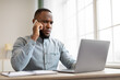 © Prostock-studio - Serious African Businessman Talking On Phone Sitting In Modern Office