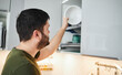 © snedorez - Young man washing dishes in the kitchen.