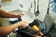 © snedorez - Young man washing dishes in the kitchen.