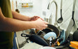 © snedorez - Young man washing dishes in the kitchen.
