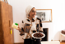 Young Muslim Woman With Plate Of Dates And A Gift