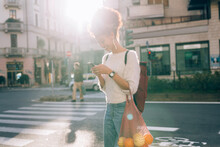 Young Woman In City, Looking At Phone