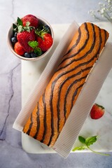 Wall Mural - Strawberry Swiss roll or Roulade with cream filling and chocolate drizzle, selective focus