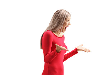 Wall Mural - Excited young woman in a red dress gesturing and screaming