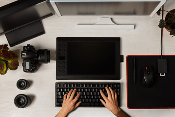 Poster - top view of hands typing on keyboard in front of two monitors and graphics tablet