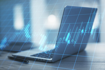 Poster - Stock market business concept with digital candlestickand glowing lines at opened laptop on wooden table background