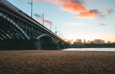 Beautiful Poniatówka beach in Warsaw at sunset, Poland, where we can see the Poniatowskiego bridge, which crosses the Vistula river separating the two parts of the city.