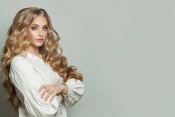 Wall Mural - attractive woman fashion model with long healthy hairstyle standing with crossed arms on white banne
