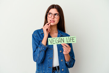 Young caucasian woman celebrating world water day isolated on pink background joyful and carefree showing a peace symbol with fingers.