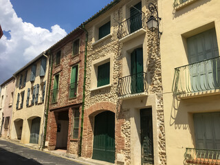 Wall Mural - Canet-en-Roussillon, France. May, 17, 2021. A line of three-story old houses on a narrow street