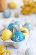 bright blue and yellow easter eggs on white wooden table
