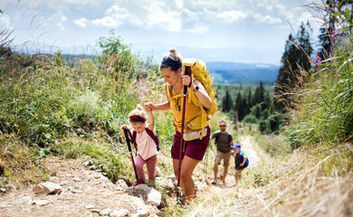 family with small children hiking outdoors in summer nature, walking in high tatras.