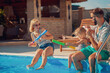 © Impact Photography - Parents and child playing with squirt guns by the pool