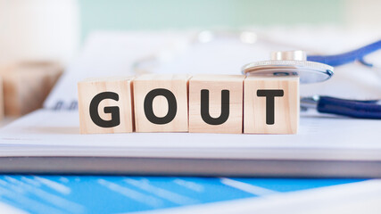 Poster - Wooden block form the word Gout with stethoscope on the doctor's desktop. Medical concept.