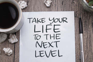 Take your life to the next level, text words typography written on paper against wooden background, life and business motivational inspirational