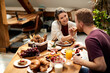 © Drazen - Happy woman feeding her boyfriend during breakfast at dining table.