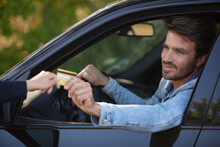 Male Motorist Passing Bank Card Through Window