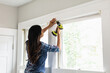 © Gerald Carter/Creative Flame - Indian woman using drill power tool to install blinds, DIY home improvement project