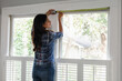 © Gerald Carter/Creative Flame - Indian woman uses tape measure tool on home window, measurements for do-it-yourself project