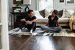 © Gerald Carter/Creative Flame - Teen son and mother talking in family room on yoga mat