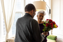 Senior man surprises wife with flowers, celebrating valentines day