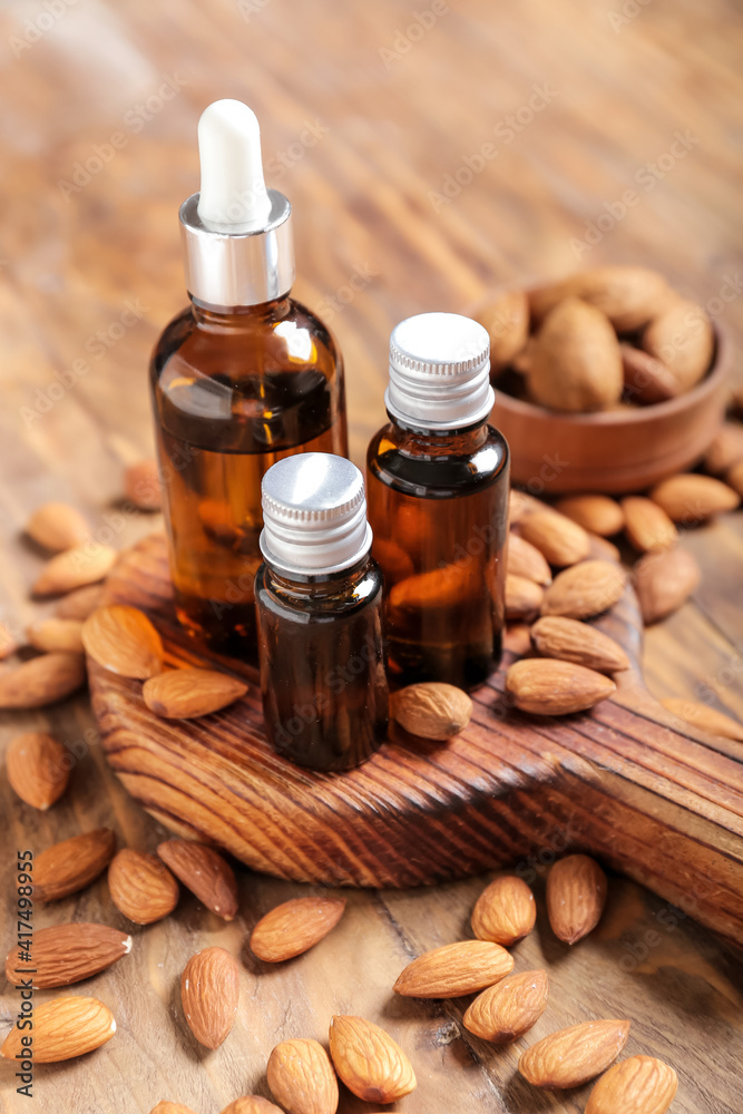 Bottles with almond oil on wooden background