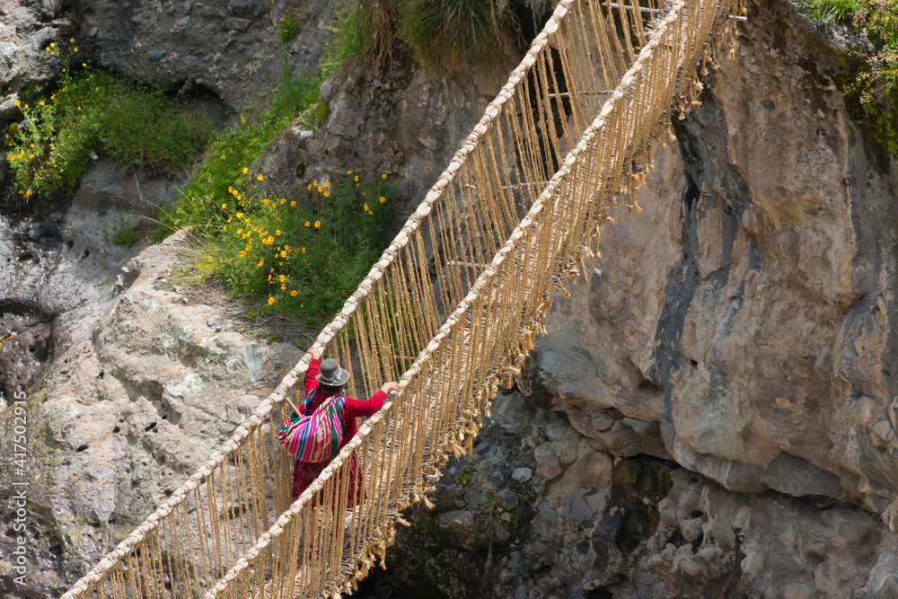 Quechua woman crossing Queshuachaca (Q'eswachaka) rope bridge, one of ...