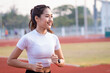 © EduLife Photos - A young Asian woman athlete runner jogging on running track in city stadium in the sunny morning to keep fitness and healthy lifestyle. Young fitness woman runs on stadium track. Sport and recreation