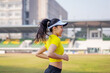 © EduLife Photos - A young Asian woman athlete runner jogging on running track in city stadium in the sunny morning to keep fitness and healthy lifestyle. Young fitness woman runs on stadium track. Sport and recreation