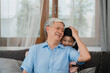 © tirachard - Asian grandfather talking with granddaughter at home. Senior Chinese, grandpa happy relax with young granddaughter girl using family time relax with young girl kid lying on sofa in living room.