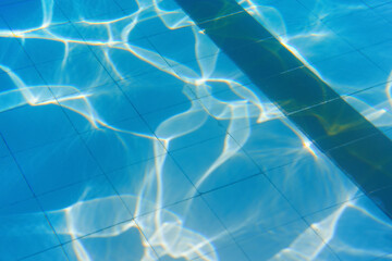 Calm water on empty swimming pool, dark lanes marks visible floor